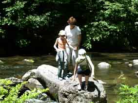 Emi and children by the stream